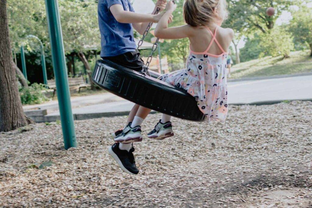 Ausflugsziele für die Sommerferien: Abenteuerspielplatz mit Schaukel und zwei Kindern