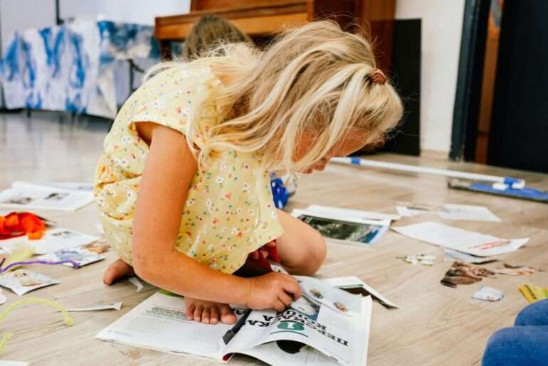 Kind bastelt auf dem Boden - Hobby statt Bildschirm