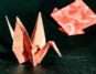 Close-up of a red origami crane with geometric patterns, highlighting delicate craftsmanship.