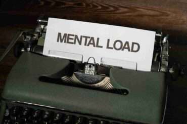 A vintage typewriter with a paper reading 'Mental Load', symbolizing stress and responsibility.