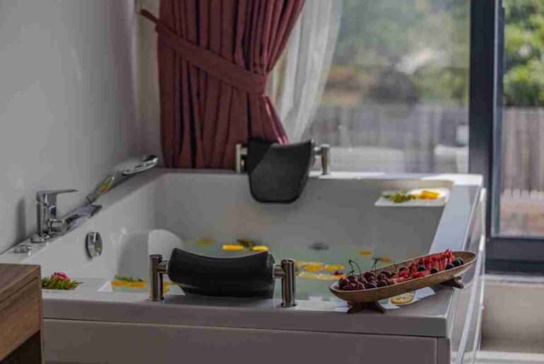 Relaxing indoor bath scene with fruits and petals, perfect for spa or luxury home vibes.